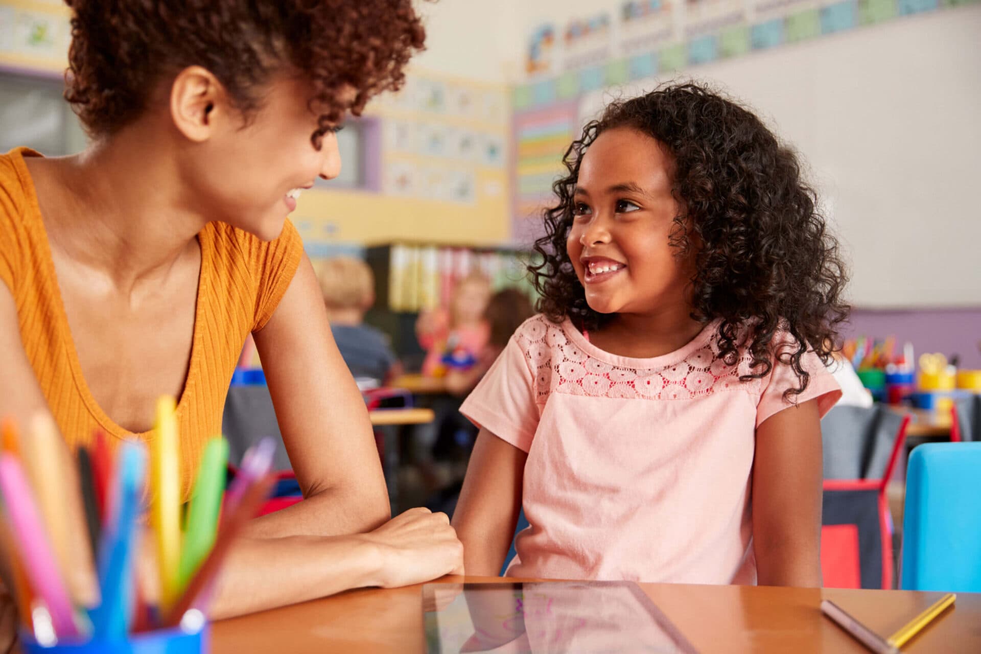 A teacher and a child smiling at each other in a Morgan’s Early Learning classroom